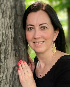Jaskó Andrea Slate-Lite értékesítő, fekete felsőben, fatörzs mellett