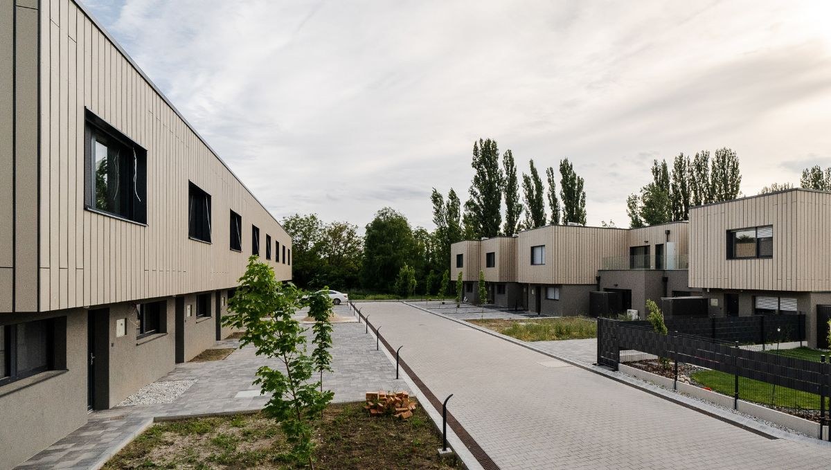A lakóházak közötti belső út térkővel burkolva, két oldalán a fatáblás homlokzatú épületsorok.